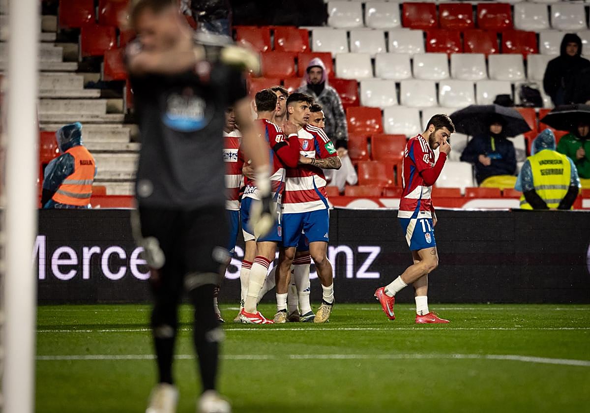 La grada, semivacía por la lluvia, festeja uno de los goles del Granada.