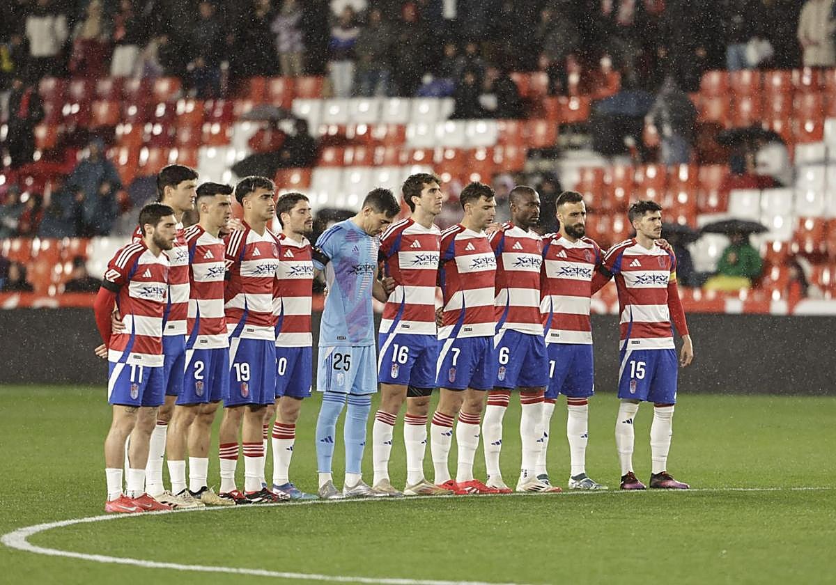 Los futbolistas del Granada se abrazan durante el minuto de silencio.