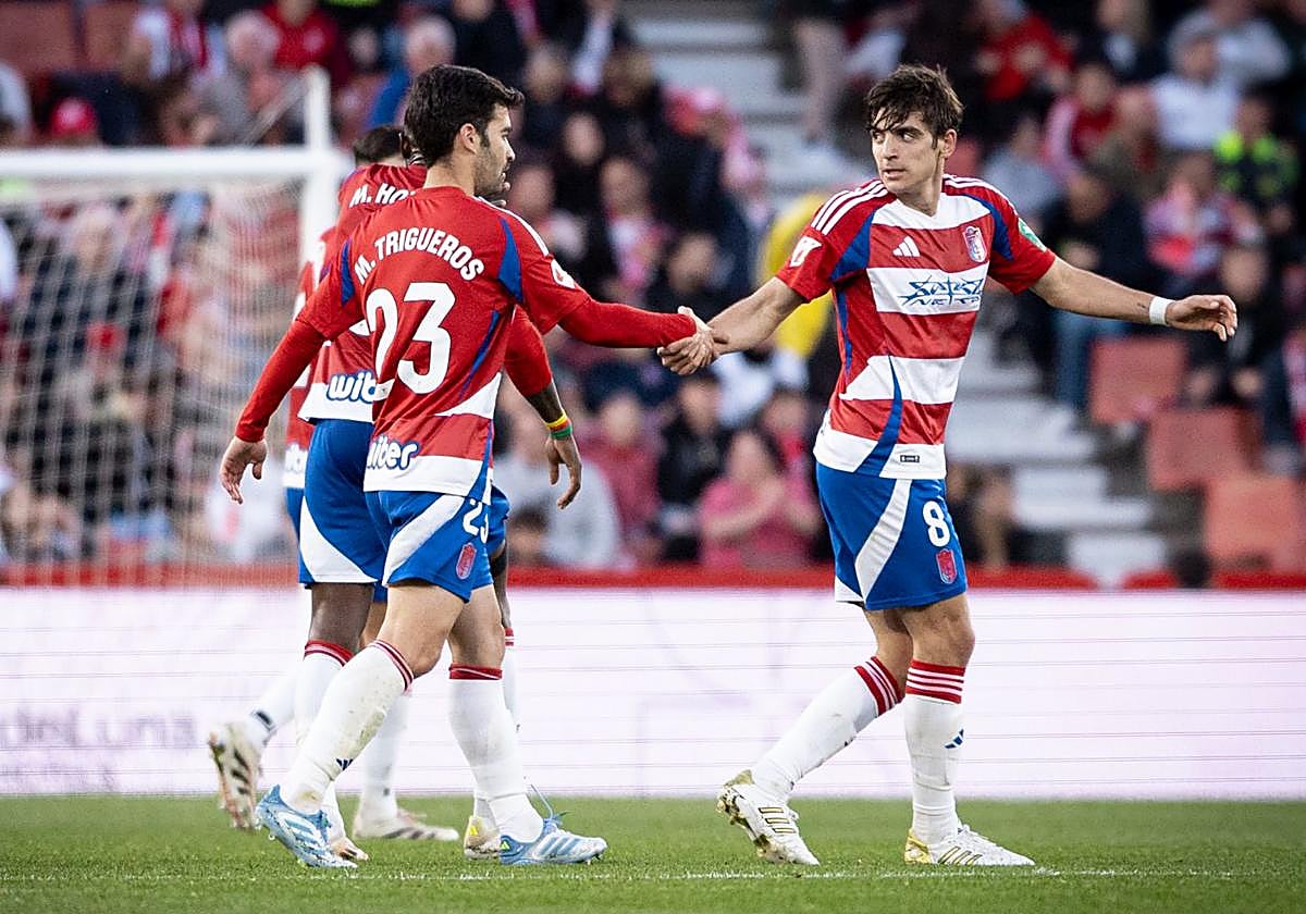 Manu Trigueros le choca la mano a Gonzalo Villar en el campo.