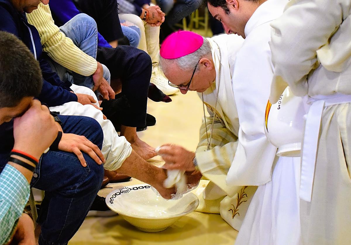 El obispo lava los pies a un preso.