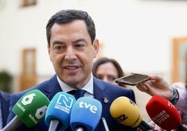 El presidente de la Junta de Andalucía, Juanma Moreno, atiende a los periodistas ante del Pleno.