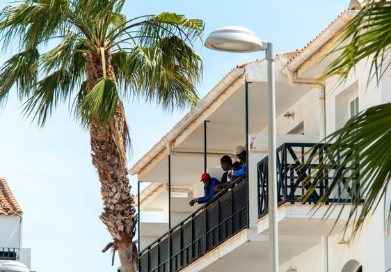 Un grupo de migrantes, asomados al balcón del hotel.