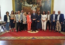 Mónica López, traje naranja, con rector, vicerrectores, secretaria general y gerente.