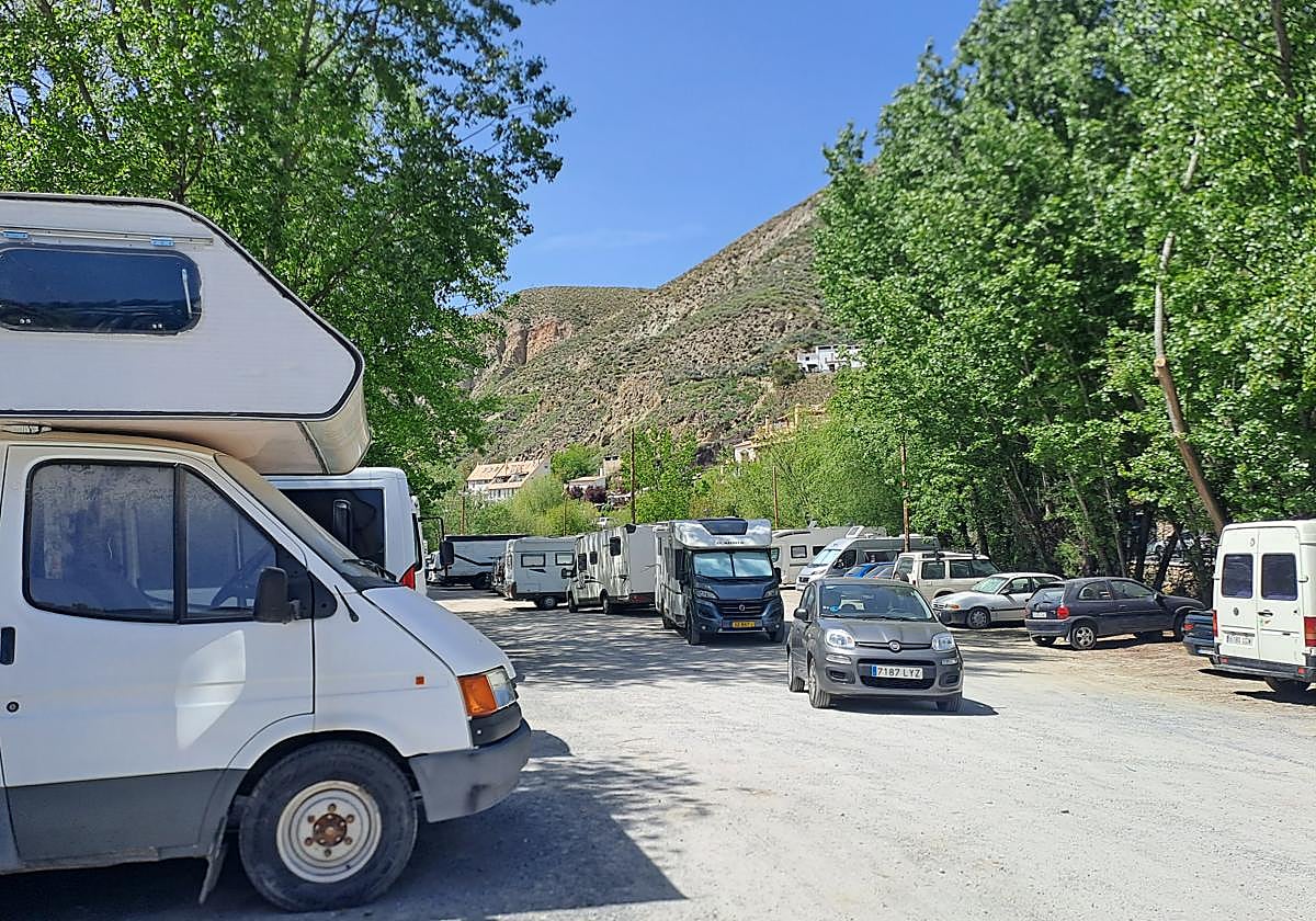 Autocaravanas en el aparcamiento de la calle Huenes, junto al río, en el casco antiguo de Monachil.
