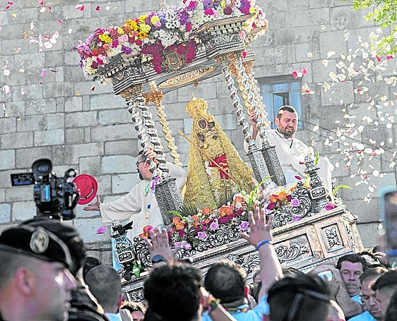 La Virgen bajo un mar de pétalos enfila la misa.