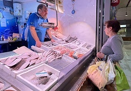 Fede Navarro atiende a una clienta en su puesto de pescados y mariscos en el Mercado de San Francisco.