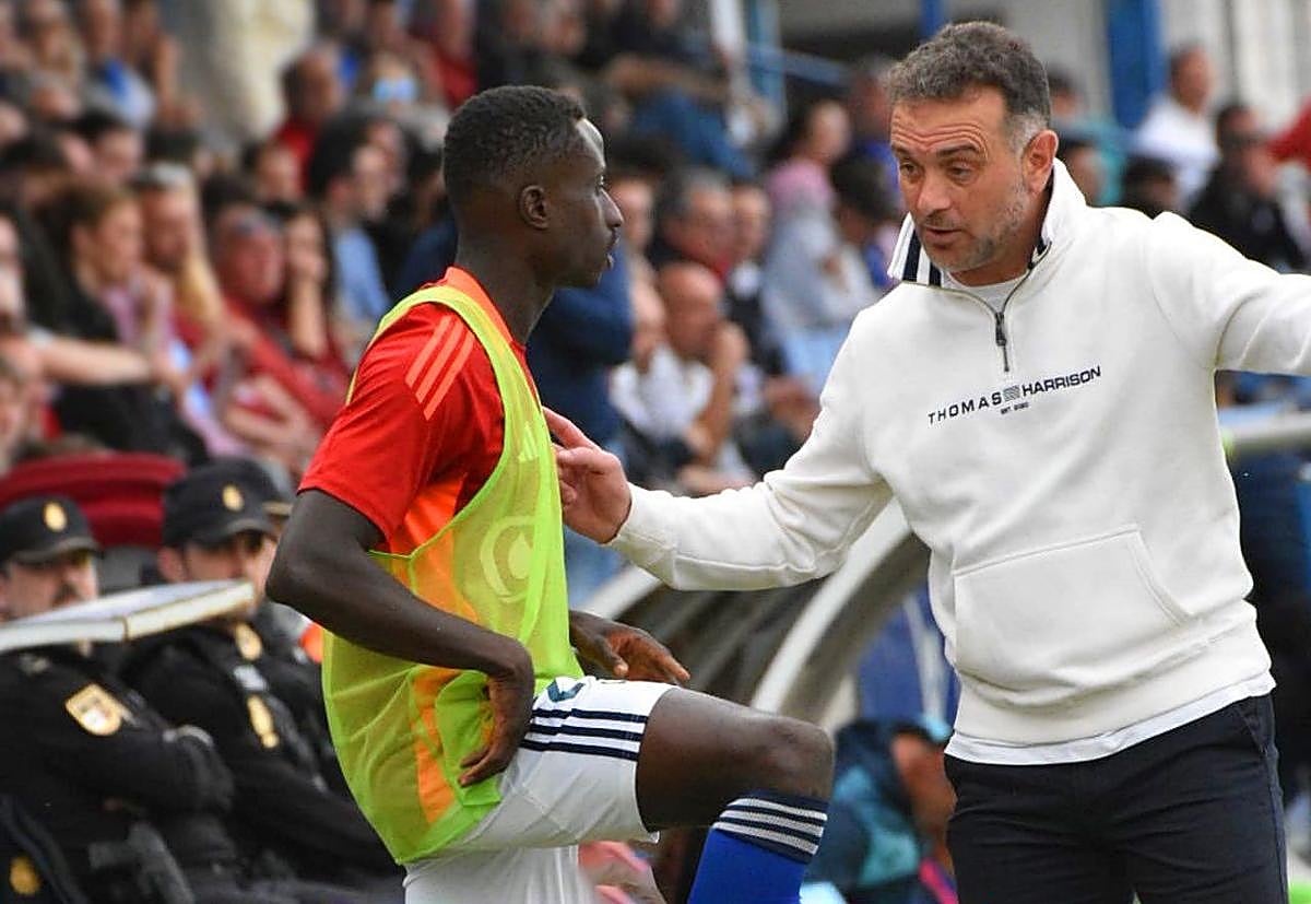 Pedro Diaz dando indicaciones a Samu Gomis antes de entrar al césped de Linarejos.