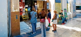 Una farmacia en el Paseo de Almería atiende a los clientes desde la puerta ante la falta de fluido eléctrico para que puedan pasar sin tropiezos.