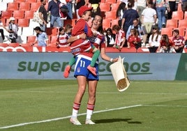 Andrea Gómez sostiene a un joven aficionado tras la derrota con el Real Madrid.