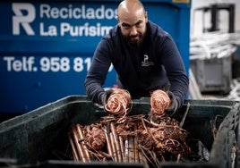 Un empleado de Reciclados La Purísima enseña una muestra del cobre que recepcionan en la empresa.
