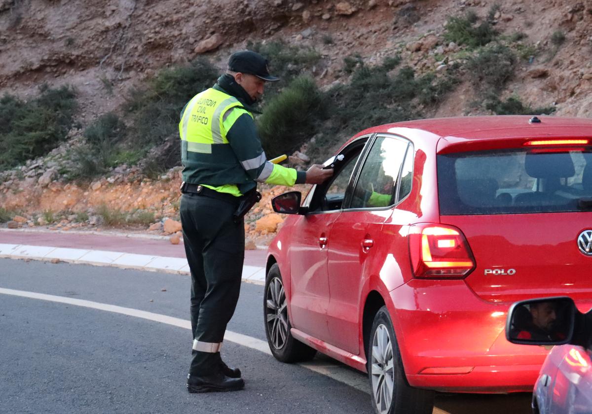 Un agente de la Guardia Civil de Tráfico practica un test de alcohol a un vehículo en El Cañarete.