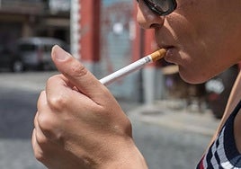 Una persona enciende un cigarrillo.