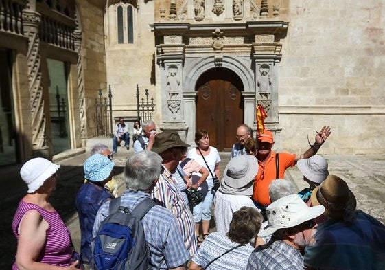 Un grupo de turistas atiende las explicaciones de un guía en la Alcaicería.