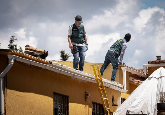 Agentes de la Guardia Civil inspeccionan el tejado de la vivienda.