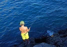 Un niño pesca con caña en la Punta de la Mona.