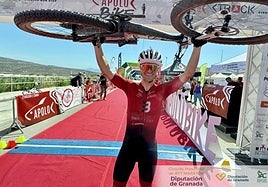 Un eufórico Miguel Molina levanta la bicicleta en la meta lojeña.