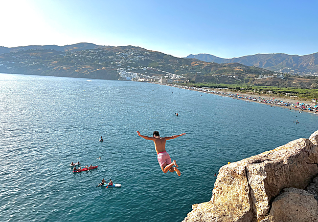 Un joven tirándose al agua por el peñón de Salobreña.