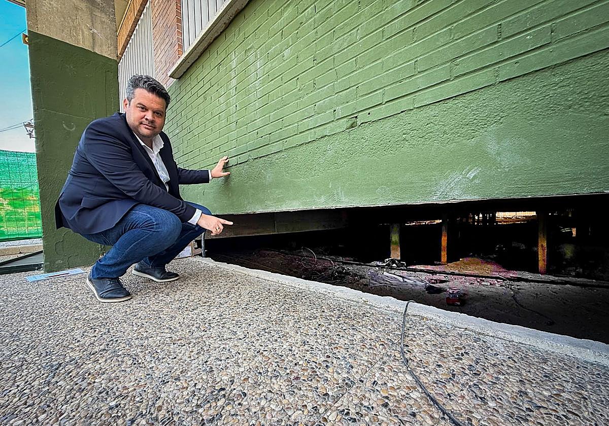 El alcalde de Maracena, Carlos Porcel, señala el espacio debajo del colegio donde se hace la obra.
