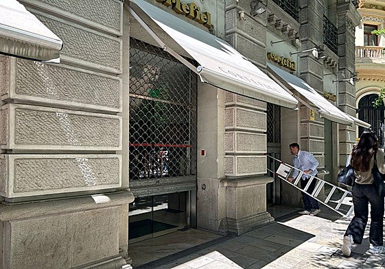 Un comercio cierra su persiana el día del apagón.