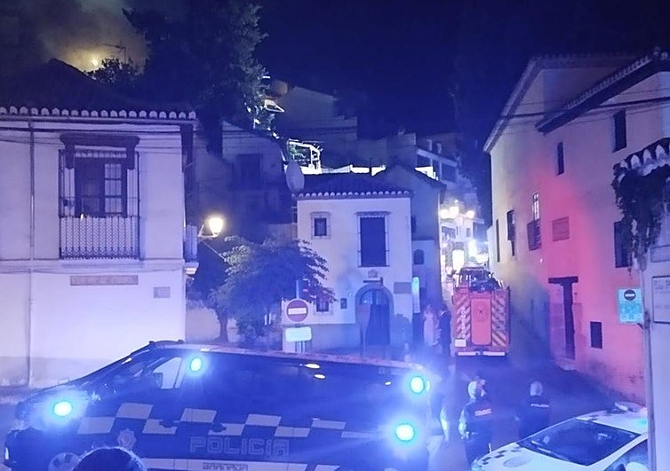 Vehículos policiales y de los Bomberos en el Peso de la Harina. Arriba a la izquierda, las llamas en el tejado.