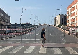Una señora pasa ante el puente de la avenida del Mediterráneo, ya cortado al tráfico.