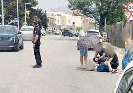 Varias personas socorren a un motorista herido en Maracena.
