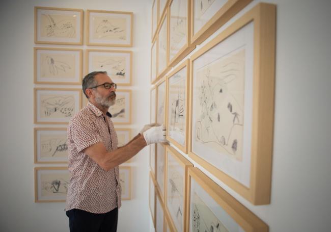 Francisco Baena coloca una de las obras de la última exposición.