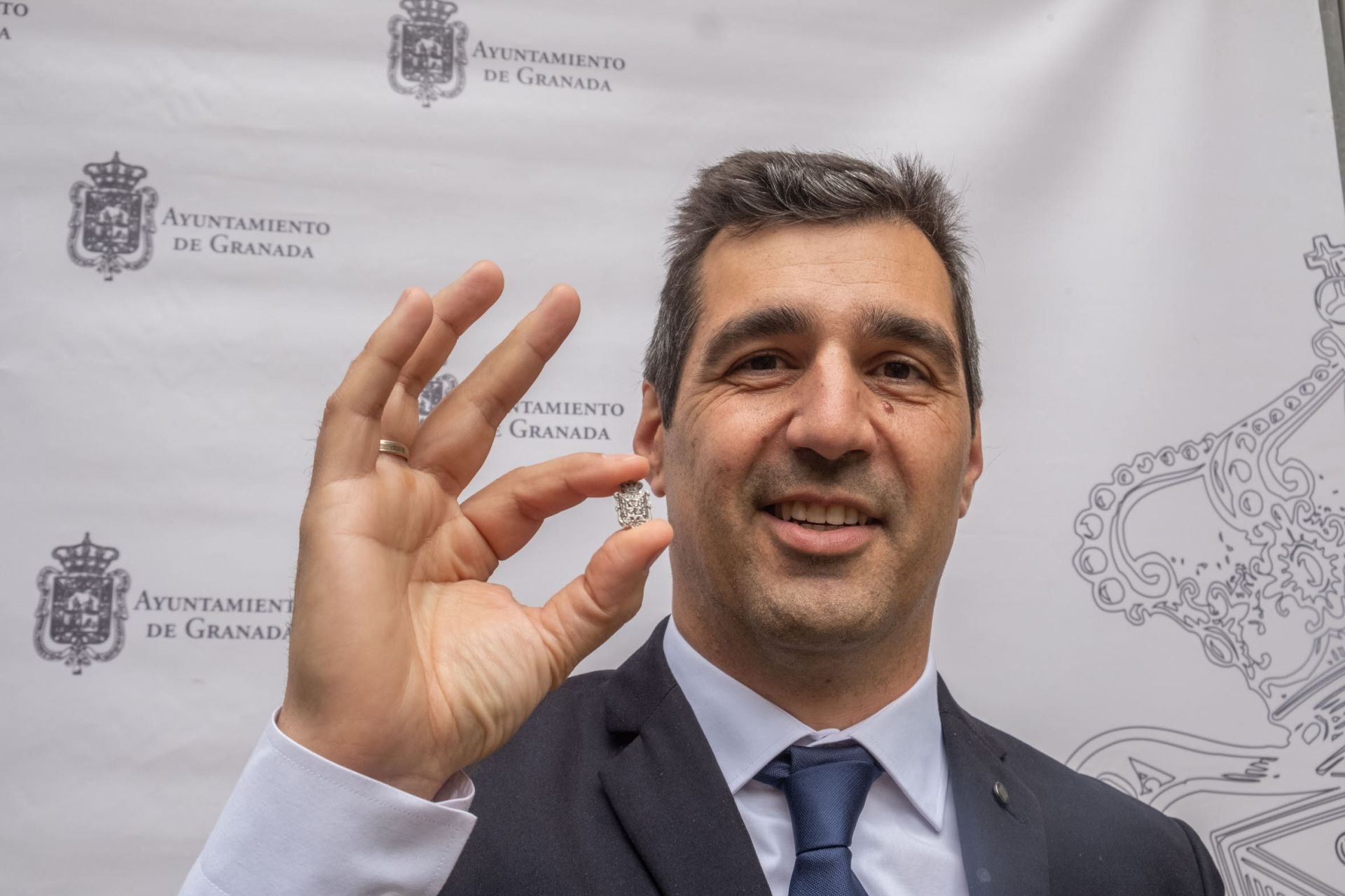 Pablo Pin muestra orgulloso su pin, con el escudo de la ciudad, distinción que recibió del Ayuntamiento de Granada.