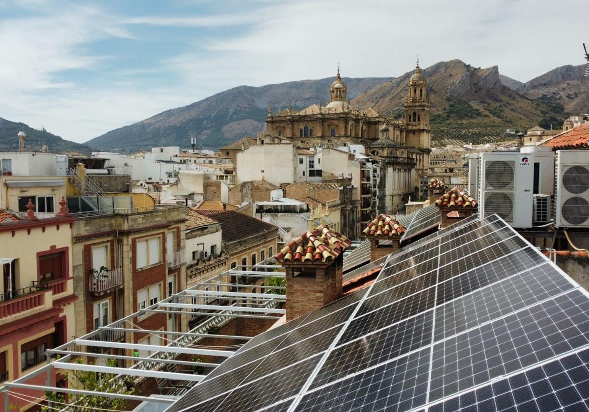 Dos instaladores trabajan en los paneles solares en el tejado de un edificio de viviendas.
