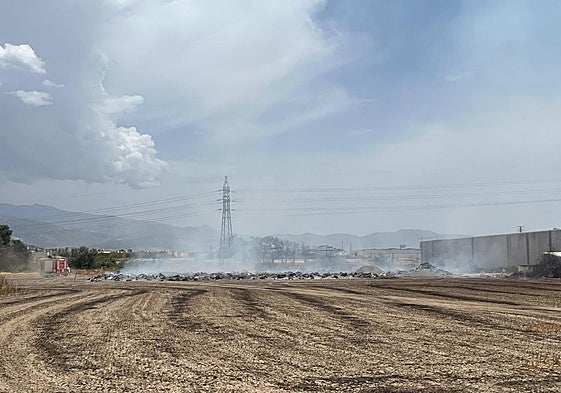 El incendio en un descampado próximo a las naves ha propiciado la intervención de Bomberos de Granada.