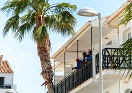 Un grupo de migrantes, asomados al balcón del hotel.