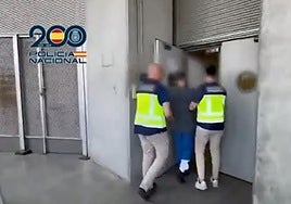 El sospechoso, escoltado por dos policías en Barajas.