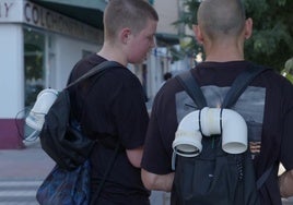 Dos voluntarios con su sensor en la mochila toman datos de un árbol de Granada.