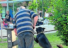 Un perro bebe agua de la fuente ubicada junto al parque infantil.
