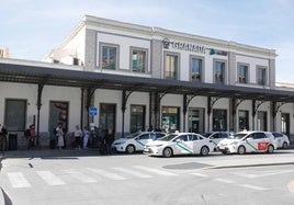 Taxis y viajeros junto al antiguo edificio de la estación.