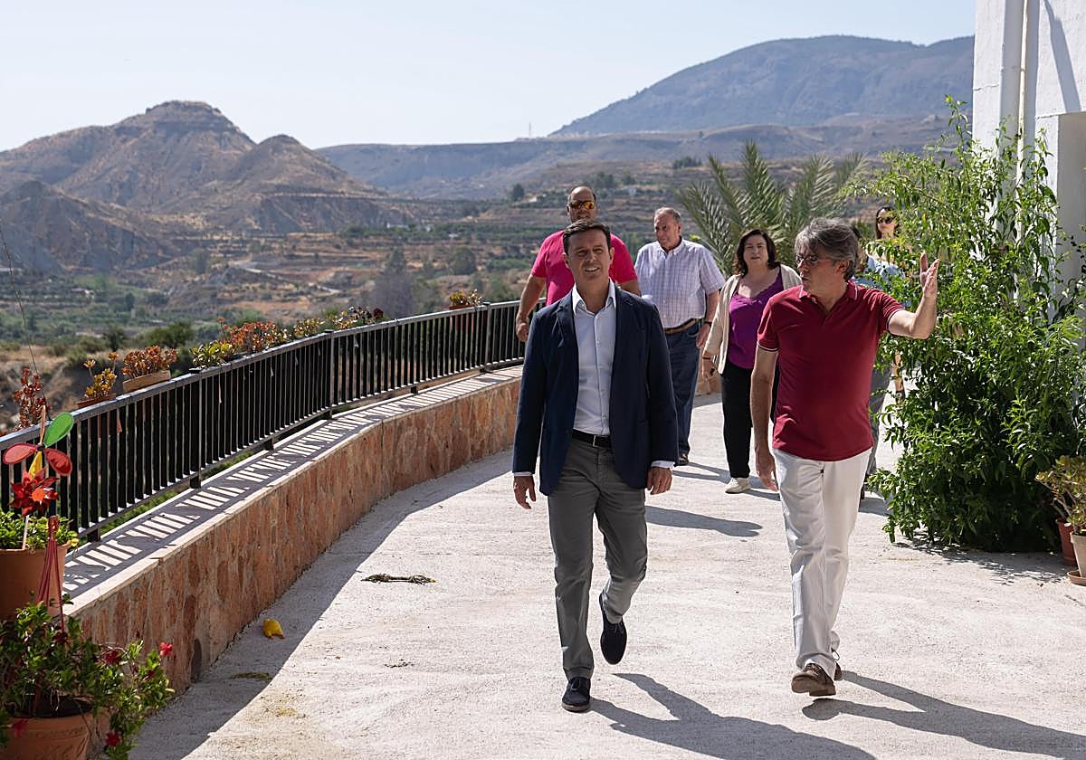El alcalde de Bentarique, Modesto Martínez, enseña una de las calles de este municipio de la Alpujarra al presidente de la Diputación.
