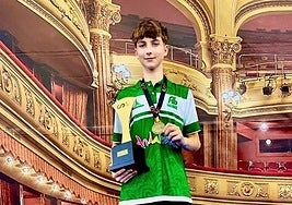 El joven campeón posa con el trofeo y su medalla.