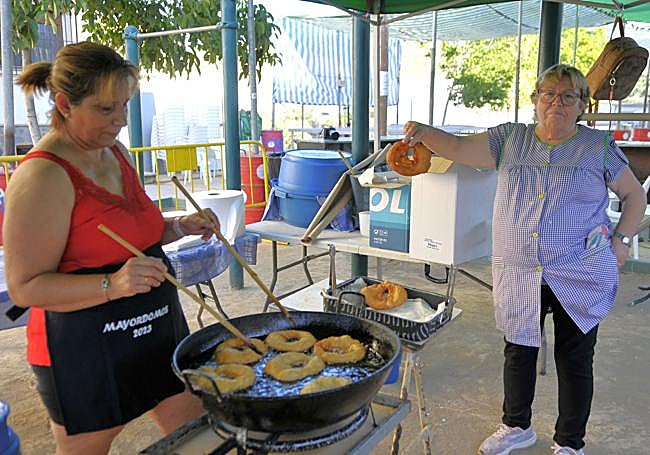 Dos mujeres haciendo buñuelos para la 'Fiesta de la Trilla' en una era de Ugíjar.