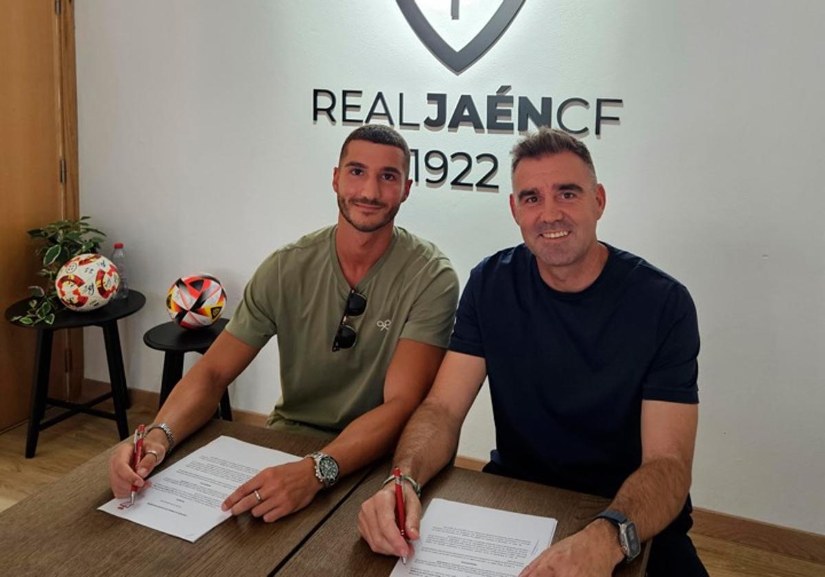 El jugador jienense firmando su renovación junto a Fran Anera.