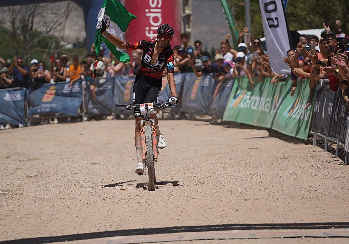 David Valero apura los últimos metros con una bandera de Andalucía bajo los aplausos de sus vecinos.