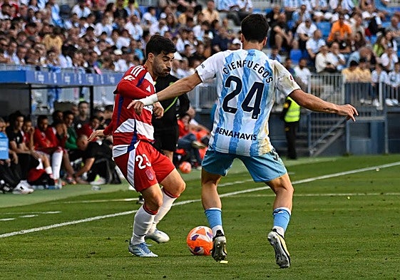 Manu Trigueros juega un balón ante la presión de un futbolista del Málaga en La Rosaleda.