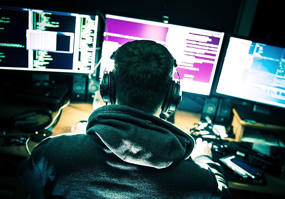 Un hombre ante varias pantallas de ordenador.