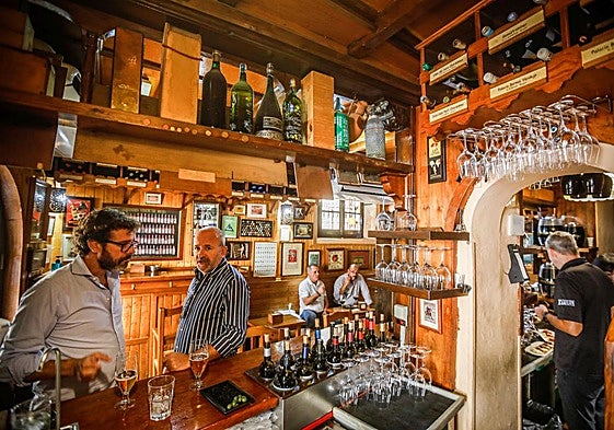 Varios clientes disfrutan de una consumición en un bar de Granada.