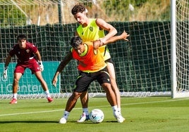 Marcos Peña protegiendo el balón ante Dzodic en un entrenamiento.