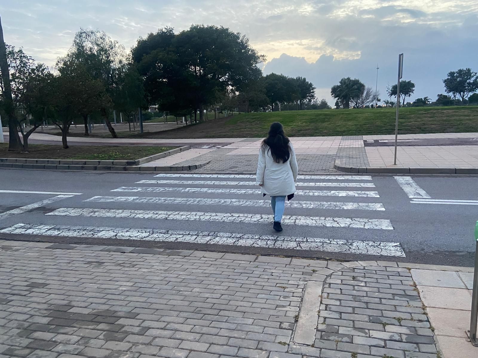 Una persona cruza un paso de peatones en El Toyo.