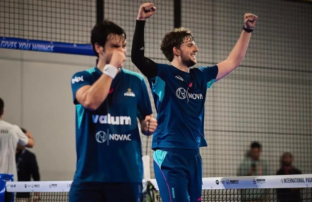 Mike Yanguas, en segundo plano, levanta los brazos en señal de victoria.