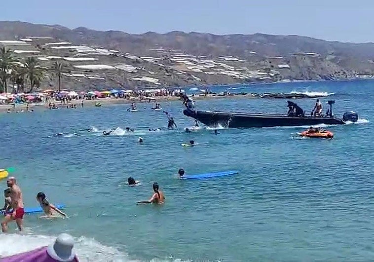 Desembarco de inmigrantes a plena luz del día en la playa de Castell de Ferro llena de bañistas