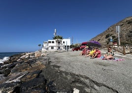 Los vecinos sentados en un pequeño hueco de arena en la playa de Castillo de Baños.