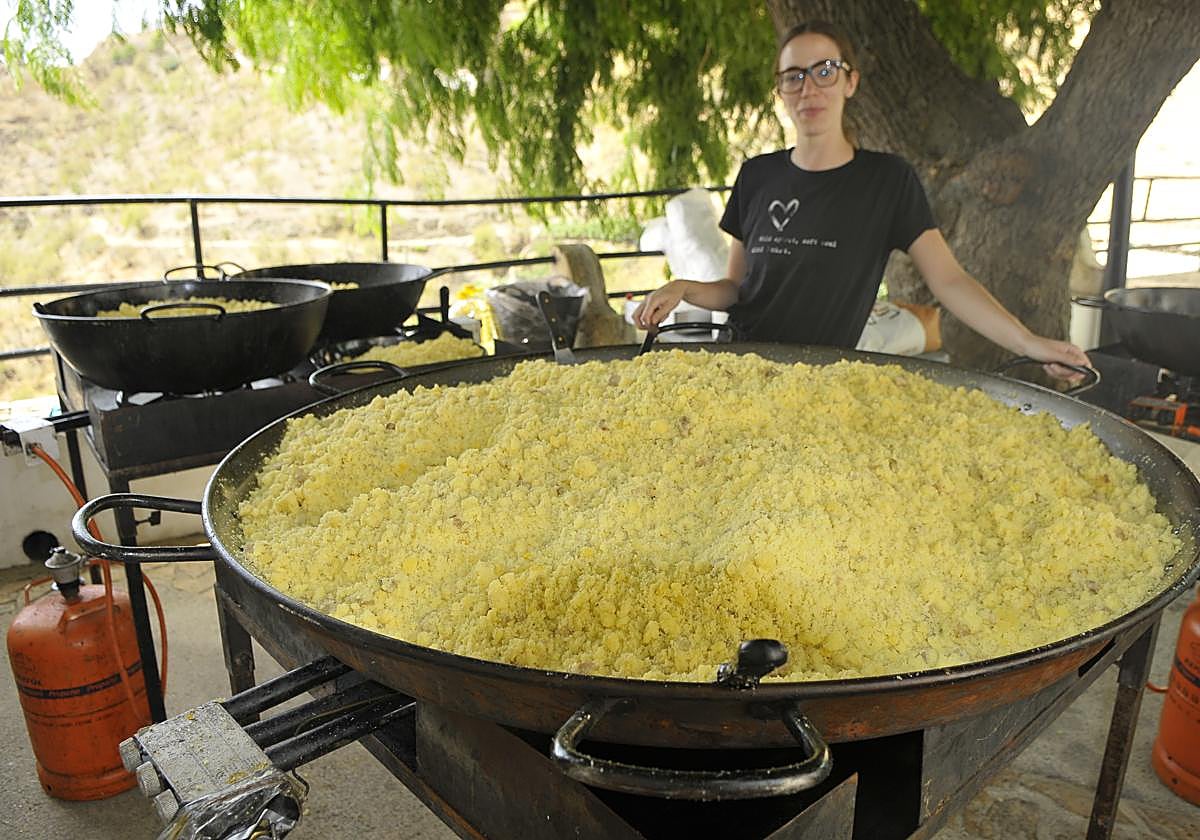 Una cocinera preparando las migas.