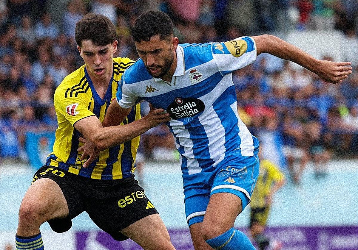 El goleador Eddahchouri protege un balón contra un futbolista del Oviedo.